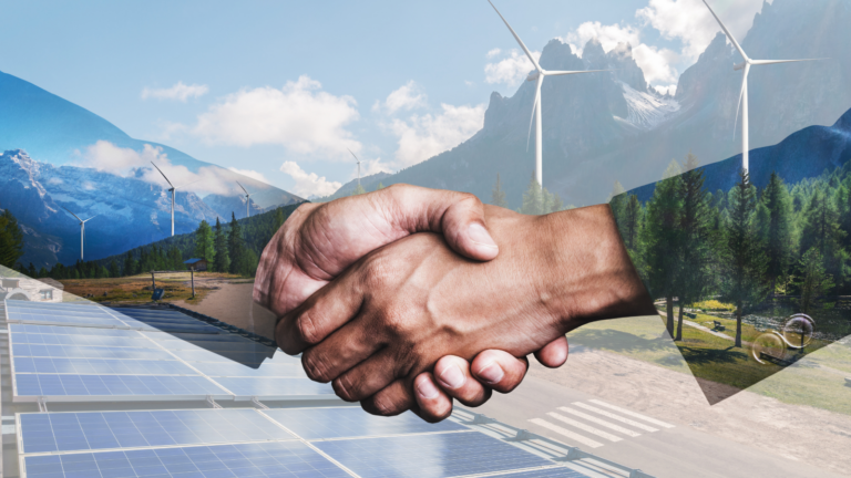 Shaking hands in front of landscape with wind turbines